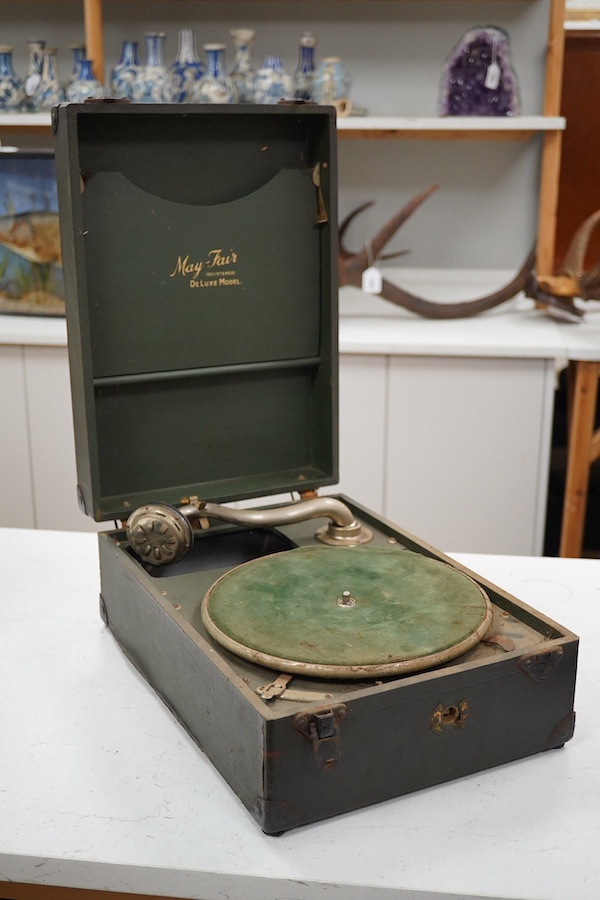 Two gramophone players; an oak cased HMV tabletop gramophone on a similar style mahogany gramophone record stand, height of stand 72.5cm, together with a May-Fair Deluxe Model portable gramophone player. Condition - poor